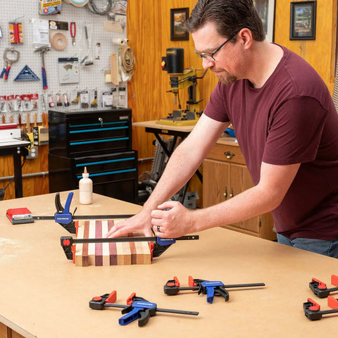 Man using One Handed Bar Clamps Set for Woodworking, Six Pack Quick Change F Clamp and Spreader on wooden project