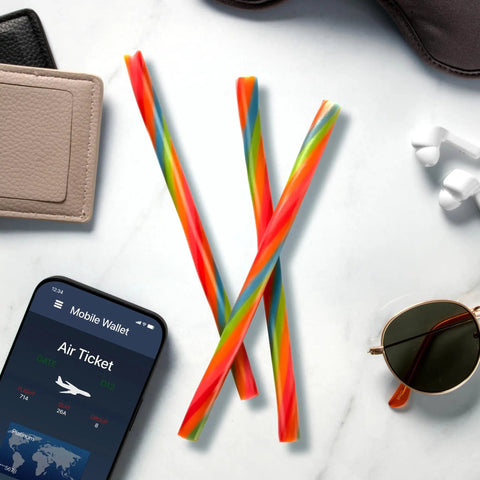 Ropes Candy Twisted Rainbow Punch Flavor Soft And Chewy 9 Oz Pack on a table with smartphone and sunglasses.