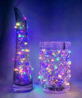 8 Pack 7Ft Fairy Lights With 20 LED Twinkle String Lights Battery Operated wrapped around colorful glass vases.