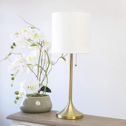 Tapered Fabric Drum Shade Table Lamp In Gold And White With Pull Chain Switch 8 By 8 By 21 Inches beside white orchid plant