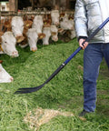 Five-Tine Pitchfork For Gardening 57-Inch Heavy Duty Garden Fork With Fiberglass Handle used to spread hay in a barn.