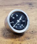 Front view of 60 psi motorcycle oil pressure gauge with black dial, white numerals, and chrome bezel.