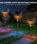 Three 3 In 1 Bug Zapper For Outdoors Solar Powered With Realistic Flame Light And RGB Projector installed in garden setting.