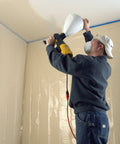 Person using the Pro Grade Electric Texture Sprayer Featuring Three Ready To Roll Swappable Nozzles For Acoustical Popcorn Knockdown.