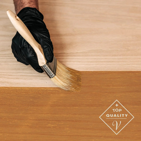 Applying Fast Track Cedarwood Wood Stain for Home Updates with a brush on raw timber surface.