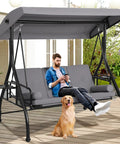 3 Seat Outdoor Porch Swing With Adjustable Canopy And Convertible Bed in garden, with man and dog lounging on it