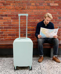 20 Inch Carry On Luggage With Usb Charging Port And Cup Holder Abs Hardshell Suitcase smooth rolling next to a man with a map.