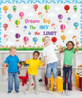 Children in front of Dream Big Bulletin Board Set 66 Pieces With Hot Air Balloons Cloud Borders 3D Honeycombs Kites And Sky Themed Decor