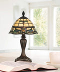 Fieldstone Finish Table Lamp With Art Glass Shade In Black, Tiffany Inspired Lighting on desk with open book and teacup, bright room.