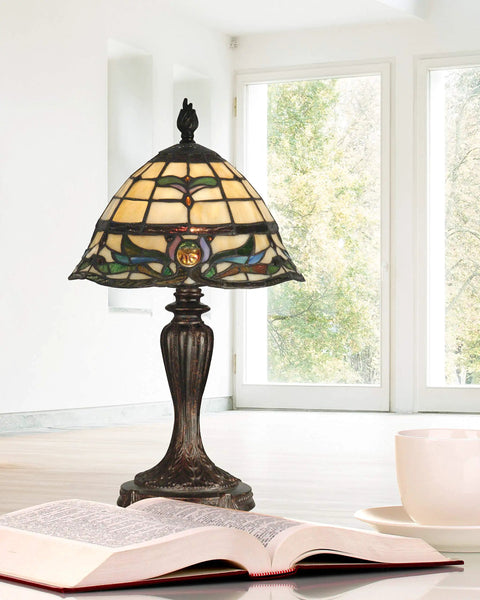 Fieldstone Finish Table Lamp With Art Glass Shade In Black, Tiffany Inspired Lighting on desk with open book and teacup, bright room.