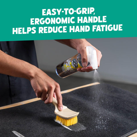 Heavy Duty Interior Carpet And Upholstery Detailing Brush With Durable Bristles For A Deep Clean Of Car Mats Seats And Fabric Ergonomic Grip For Comfort And Total Control being used on a car mat with cleaning spray.