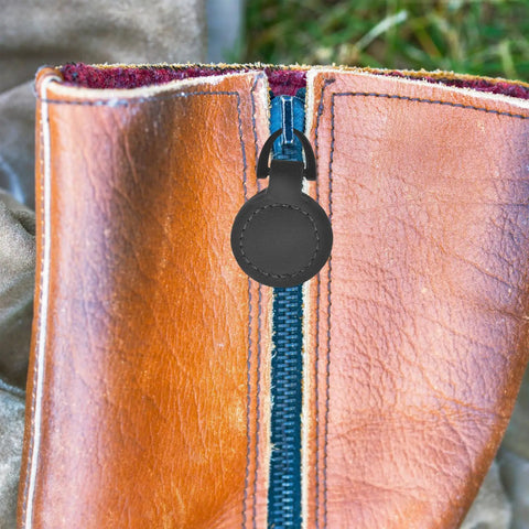 Close-up of Five Piece Set Of Badass Black Alloy Zipper Pull Replacement Tabs for Heavy Duty Backpacks on leather zipper.