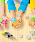 Children showcasing vibrant soaps made with the Soap Making Kit For Kids Create 8 Colorful Soaps With Fragrance And Glitter Using Four Molds A Kid Approved Hands On Science Craft For Boys And Girls Aged 6 To 12 A Fun Educational Gift, surrounded by dyes and molds on a table.