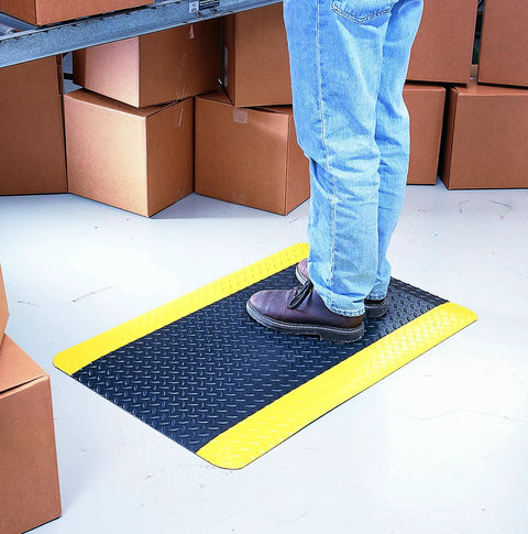 Person standing on Diamond Plate Select UltraSoft Anti Fatigue Floor Mat 4 Ft By 2 Ft 15 16th Inch Thick Black With Yellow Edge