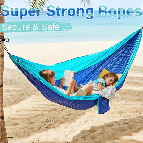 Children relaxing in Blue Outdoor Camping Hammock Portable With Tree Straps And Rope, 56 By 103 Inches, on beach