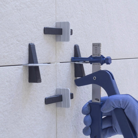 Tile Leveling System Clips And Wedges 2 Mm Black 500 Piece Set For Fast Lipless Finishes And Ultra Flat Floors Walls And Ceilings Perfect For Quick Tile Installations Time Saver Durable Easy To Use being used on wall tiles in a construction setting
