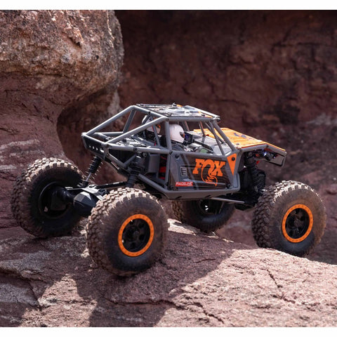 Capra UTB18 One Eighteenth Scale RC Crawler 4WD RTR climbing rocky terrain, tube chassis, portal axles, multicolor gray.