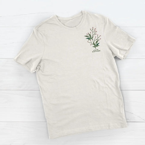 Beige t-shirt with green plant design and "Love Nature" text on a wooden surface.