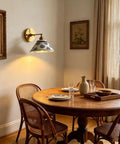 MECOLA Vintage Ceramic Shade Wall Sconce Adjustable Angle Wall Mount Light illuminating a dining area with wooden furniture.