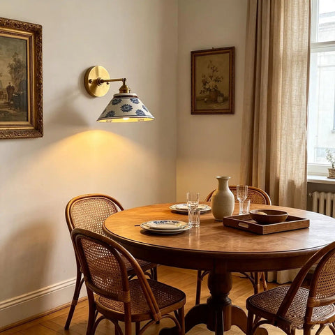 MECOLA Vintage Ceramic Shade Wall Sconce Adjustable Angle Wall Mount Light illuminating a dining area with wooden furniture.
