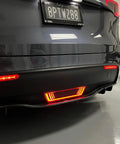 Dope Tesla Model Y Led Brake And Turn Signal Kit With Smoke Tint Lens Replaces Hitch Cover mounted on rear bumper with red lights.