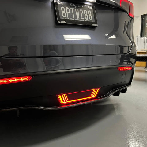 Dope Tesla Model Y Led Brake And Turn Signal Kit With Smoke Tint Lens Replaces Hitch Cover mounted on rear bumper with red lights.