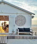 Beachfront cabin with large circular decor, outdoor seating, and sunset view
