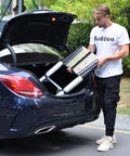 Person placing Aluminum Telescoping Ladder 16 Point 5 Feet Extension With Triangle Stabilizers into car trunk for easy transport