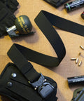 Rugged 1.5 Inch Nylon Tactical Belt With Quick Release Aluminum Buckle shown with outdoor gear on brown surface