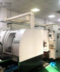 CNC milling machines in a factory; white units with control panel on left and Jarrow Tool logo.