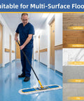 Man using Heavy Duty Industrial Dust Mop With Extra Wide Head And Long Wooden Handle on shiny floor in hallway, suitable for multiple surfaces.