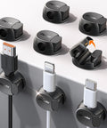 Easy Cord Organizer With Dual Spring And Clasp Cable Clips shown in black, installed on desk holding various charging cables.