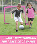 Kids playing soccer in front of Pink Pop Up Soccer Goal For Kids 4 Foot By 3 Foot Portable Backyard Net With Stakes Easy Setup