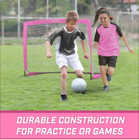 Kids playing soccer in front of Pink Pop Up Soccer Goal For Kids 4 Foot By 3 Foot Portable Backyard Net With Stakes Easy Setup