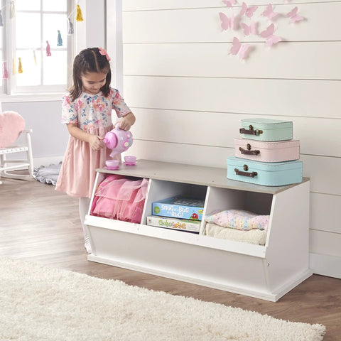 Child playing with a tea set next to a Three Bin Stackable Toy Storage Cubby Organizer For Kids Playroom And Bedroom Expandable Modular Toy Storage System For Toys And Crafts In White Gray Woodgrain, with toys inside.