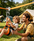 Father helping son on outdoor zip line conversion kit with smooth glide pulley system in backyard, tents in background.