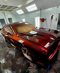 Molten Merlot Professional Car Paint Basecoat Full Gallon Volume Ready To Spray Straight Out The Can With Premium Slow Reducer For Slick Coverage And A Badass Garage Ready Finish on a freshly painted car in a spray booth.