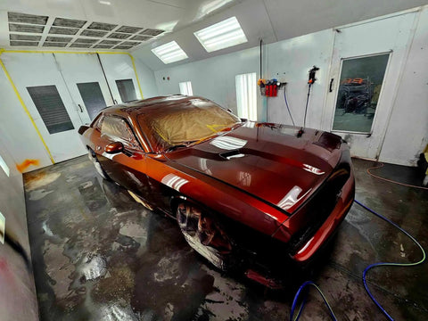 Molten Merlot Professional Car Paint Basecoat Full Gallon Volume Ready To Spray Straight Out The Can With Premium Slow Reducer For Slick Coverage And A Badass Garage Ready Finish on a freshly painted car in a spray booth.