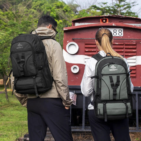 Two people with Expandable Hiking Backpack 40L To 50L For Men And Women Flight Approved Carry On Ready Travel Daypack near train