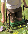 Person using Fold Away Garden Kneeler And Seat Dual Purpose With Sturdy Lightweight Steel Frame Folds Flat For Easy Storage EVA Foam Cushioned Pads Durable Powder Coated Finish Green on grass while gardening