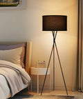 60 Inch Tripod Floor Lamp In Brushed Nickel With Gray Linen Drum Shade in cozy bedroom setting
