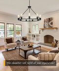 Black Wagon Wheel Chandelier Total Showstopper Lighting Fixtures in matte black above a cozy living room setting.