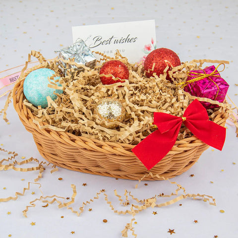Gift basket with brown crinkle cut paper shred filler and festive ornaments, showcasing crinkle cut paper shred filler for gift baskets and boxes.
