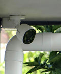 Indoor Outdoor 1080p Security Camera With Infrared Night Vision, PIR Motion Sensor, installed under an eave for home surveillance.