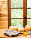 Wooden window with heavy duty aluminum screen door latch and autumn decor in a cozy setting