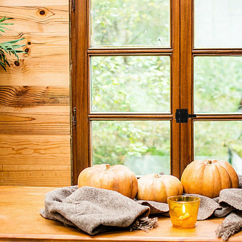 Wooden window with heavy duty aluminum screen door latch and autumn decor in a cozy setting