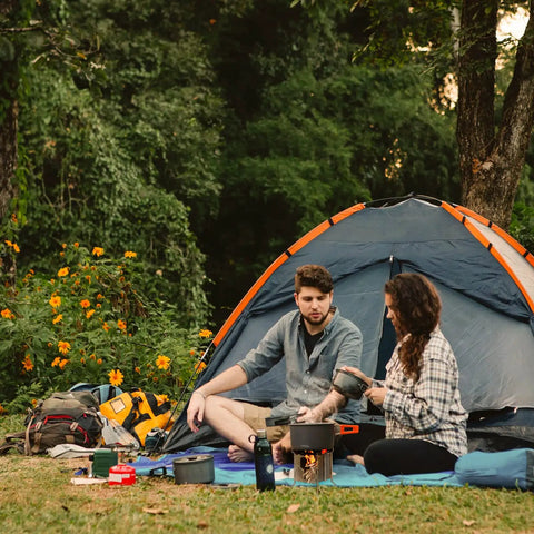 Campers using All Fuel Stainless Steel Camping Stove For Solo Campers Folding Backpacking Stove outside a tent in a forest