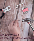 Using hammer from 39 Piece Pink Household Tool Set With Storage Case for Home DIY Projects on wooden surface