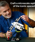 Man assembling Project Hail Mary Microscale Spacecraft Model Collectible Set For Adults, Ages 14 Plus, on gravity simulation stand.