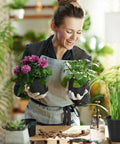 Woman gardening with 120 Pack 4 Inch Plastic Nursery Pots With Drainage Holes For Seedlings And Succulents indoors.